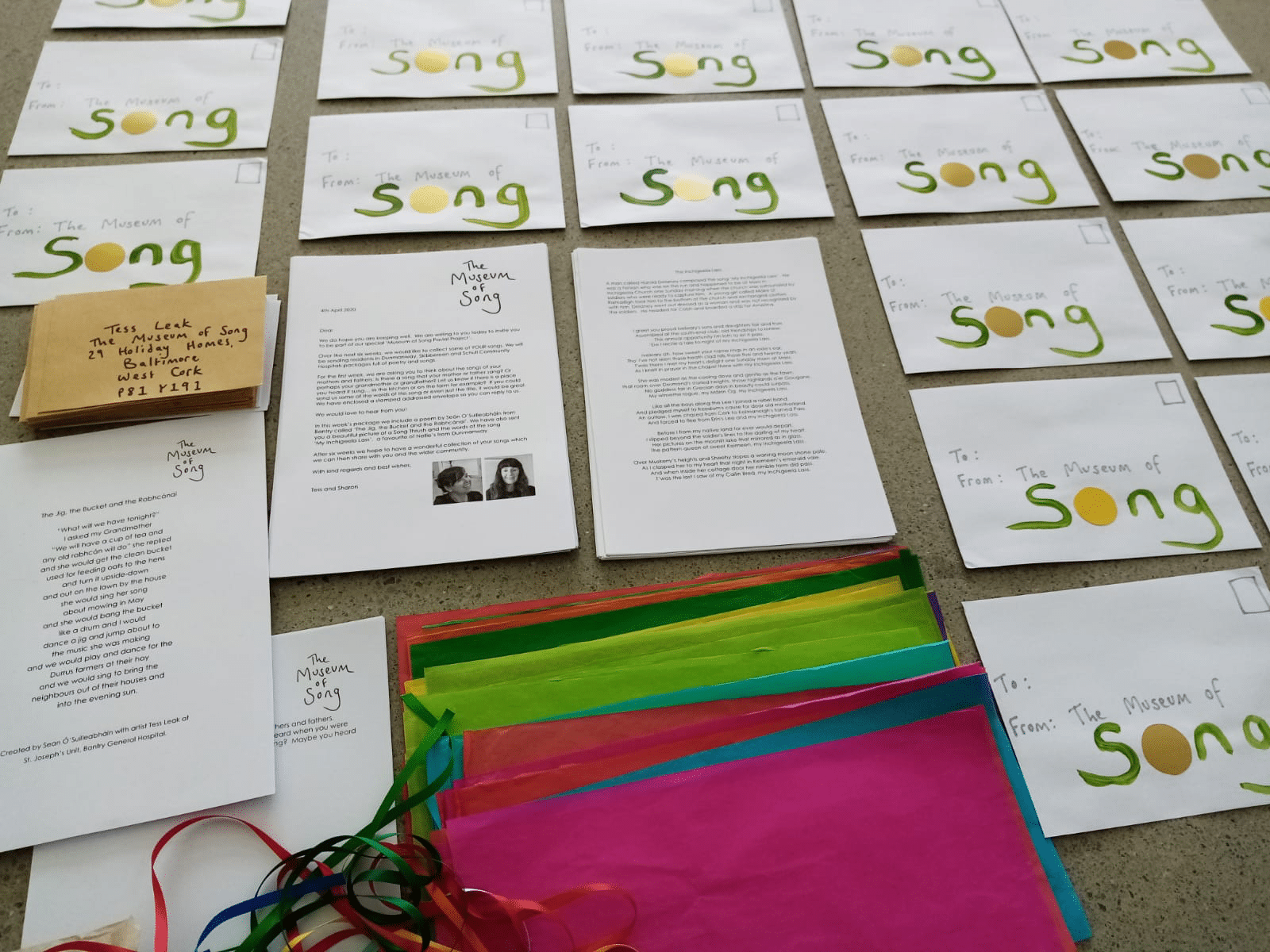 White letters with green writing lined up on a table. They will be sent out as part of the song collecting project.